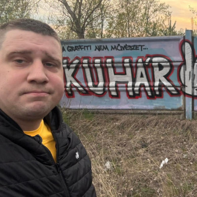 Buhár Kence pózol az őt szidó graffitivel